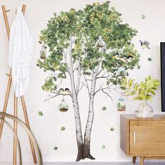 a tree with birds on it and hanging from the branches in front of a tv