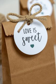 two brown paper bags tied with twine and tag that says love is sweet on them