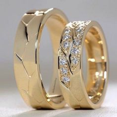 two gold wedding rings with diamonds on them