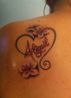 the back of a woman's shoulder with flowers and an angel tattoo on it