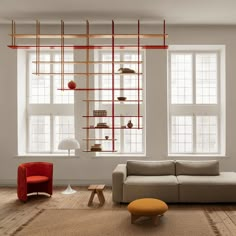 a living room filled with furniture next to two large windows covered in bookshelves