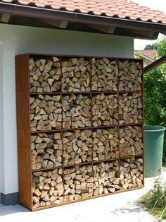 a large stack of logs sitting next to a building