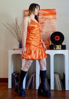 This unique shiny orange mini dress is fun and flirty for any occasion. It's a halter mini dress, with a gathered comfy bodice and bouncy bubble mini skirt. Mint condition.  Bust: 36' Waist: 29' Hip: 40' Length: 40' Orange Ruched Mini Dress, Fitted Flirty Orange Mini Dress, Orange Flirty Dress With Spaghetti Straps, Flirty Orange Dress With Spaghetti Straps, Flirty Orange Dresses With Spaghetti Straps, Flirty Orange Spaghetti Strap Dress, Orange Ruffled Mini Dress For Cocktail, Orange Ruffled Mini Dress, Summer Satin Mini Dress For Costume Party