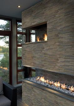 a fire place in the middle of a living room next to a couch and window