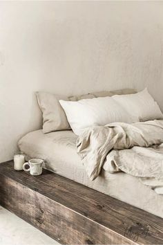 an unmade bed with pillows and blankets on it