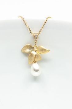 The teardrop-shaped pearl is attached to a delicate flower through which a fine gold-plated chain runs. Product details: Material: brass, gold plated, cubic zirconia Pearl (synthetic) Chain length: 45 cm Pendant: 2.2 cm x 2.2 cm (without loop) The necklace is delivered in a pretty jewelry box. --------------------------------------- You can find more wedding jewelry here: https://www.etsy.com/de/shop/CataleaM?ref=seller-platform-mcnav&section_id=21448206 You can find even more jewelry here: https://www.etsy.com/de/shop/CataleaM Orchid Necklace, Necklace With Pearls, Necklace Flower, Golden Flower, Pretty Jewelry, Brass Gold, Delicate Flower, Pretty Jewellery, Jewelry Wedding