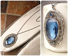 Offering an absolutely stunning vintage 1930s to 1940s era Art Deco sapphire blue bezel set faceted glass crystal, rhinestone, and silver plated filigree pendant necklace.  This is the perfect "Something Old" and "Something Blue" for the bride!   The 2 1/8 inch (5.4 cm) by just over 1 1/4 inches at 1 5/16 inches (3.3 cm) ornate embossed filigree pendant features a central oval cut bezel set faceted glass crystal in the most beautiful shade of sapphire blue.  Accenting the glass crystal are 2 pave set sapphire blue crystal rhinestones.  The pendant hangs from a silve tone replacement chain that fastens with a ring clasp and measures 24 1/4 inches (61.6 cm) around with an additional drop for the pendant.  This treasure is in excellent vintage condition with no cracks or chips to the glass cr Heirloom Blue Necklaces For Weddings, Vintage Sapphire Necklaces For Anniversary, Vintage Sapphire Necklace For Anniversary, Vintage Blue Jewelry For Wedding, Vintage Blue Wedding Jewelry, Antique Blue Jewelry For Wedding, Antique Blue Wedding Jewelry, Blue Filigree Necklace For Wedding, Art Deco Pendant Necklace