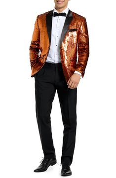 Drenched in golden sequins and finished with satin lapels, the jacket of this entrance-making tuxedo pairs with pleated black trousers and a coordinating bow tie to finish the standout look. Jacket has peaked lapels; four-button cuffs; chest pocket; welt pockets; interior pockets; side vents Trousers have zip fly with button-tab closure; slant pockets; back pockets Jacket is lined Unhemmed 100% polyester Machine wash, line dry Imported Glamorous Fitted Suits For Party, Festive Sequined Party Blazer, Festive Sequin Party Blazer, Formal Long Sleeve Sequin Blazer, Long Sleeve Sequin Blazer For Formal Occasions, Glamorous Fitted Evening Suit, Fitted Notch Lapel Blazer For Gala, Luxury Suits With Notch Lapel For Night Out, Fitted Gold Blazer For Party