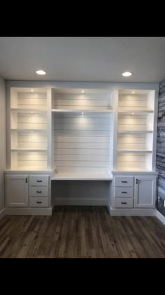 an empty room with built in shelves and white paint on the walls, along with wooden flooring