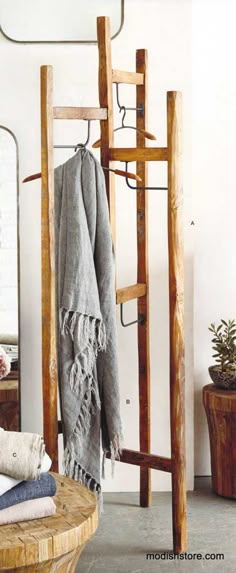 a wooden coat rack with clothes hanging on it