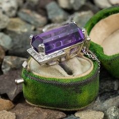 This stunning 14K white gold pendant is centered with one (1) cut-cornered rectangular step cut natural amethyst set into a four-prong setting. The amethyst is bordered with eighteen (18), bead set, round brilliant cut diamonds. The pendant measures 27.0mm X 16.9mm X 13.3mm and is suspended from a 14K white gold cable link style neck chain measuring 18 inches in length. Luxury Purple Amethyst Ring, Rectangular Shape, Luxury Purple Amethyst Rectangular Ring, Luxury Purple Rectangular Amethyst Ring, Luxury Rectangular Amethyst Ring, Rectangular Platinum Jewelry With 17 Jewels, Rectangular Platinum Jewelry For Gifts, Fine Jewelry With Purple Square Cut, Fine Jewelry Purple Square Cut, Formal Purple Amethyst Ring With Rectangular Shape