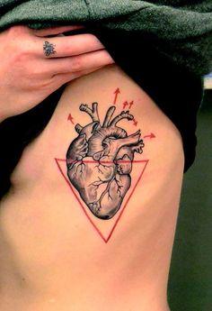 a heart tattoo on the side of a woman's stomach, with arrows going through it