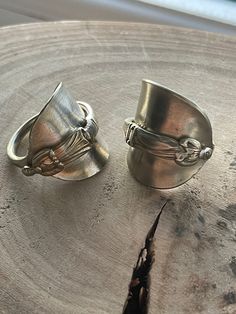 2 available.  Recycled apostle coffee spoon ring. Made from ESPN silver.  Hand hammered and formed with the bowl and stem wrapped around each other. Each one unique with lovely detail. 2 available.  Ring 1 Size UK W 2.5cm height 3cm across Ring band 5mm Ring 2 UK size U 3cm height 3.5 cm across 5mm ring band. Each ring has a brushed finish with the silver appearing an off silver/ light brass colour. Each spoon has natural patina and wear and dents and dings.  Large rings that would look amazing on the thumb. Ring From Spoon, Large Rings, Saddle Ring, Ring Plate, Silver Gift Wrap, Spoon Ring, Spoon Rings, Silver Lights, Coffee Spoon