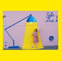 a woman standing in front of a giant yellow lamp