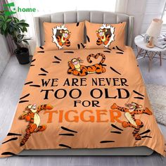 a bed with two pillows on top of it and the words, we are never too old for tiger