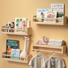 three wooden shelves holding books, toys and other children's items on them against a yellow wall