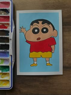 an image of a cartoon character on a card next to some watercolors and paintbrushes