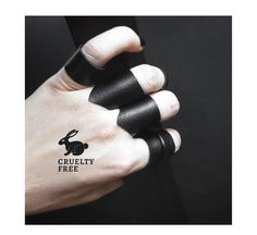 a person's hand with two black rings on it and the word cruelly free