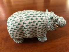 a green and white bear figurine sitting on top of a wooden table