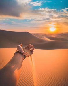 a person holding their hand out in the desert