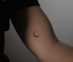 a woman's arm with a crescent tattoo on it