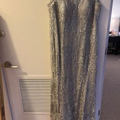 Long Sleeveless Evening Gown. Gorgeous Design. Worn One Time Only. Like Brand New. The Color Is Silver/Gray. Great To Add To Your Evening Collection Wear. The Size Is 18. Elegant Silver Sleeveless Gown, Silver Sleeveless Dress For Gala, Silver Sleeveless Sequined Gown, Sleeveless Silver Sequin Gown, Silver Sequined Sleeveless Gown, Silver Sleeveless Prom Dress, Silver Sleeveless Evening Dress With Sweep Train, Silver Sleeveless Party Gown, Silver Evening Dress For Mother Of The Bride