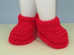 a pair of red crocheted slippers sitting on top of a white table