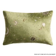 a green pillow with sun, moon and stars on it