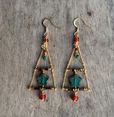 "Delightful handmade original designer earrings in red and green Xmas colors. An open Christmas tree with turquoise green five pointer star makes a statement for Christmas. The tree will swing about as you go about day and night. I have used Czech glass beads, barrel and tube beads to design this Xmas tree. Length top of earring hook is 74mm (3\"). Width 25mm (1\") I have used surgical steel gold plated earring hooks, 14Kt gold filled hooks available for additional cost. Also has a sister earrin Handmade Christmas Earrings For Celebration, Green Beaded Earrings For Festive Occasions, Handmade Dangle Jewelry For Holidays, Bohemian Green Jewelry For Holiday, Handmade Earrings For Holiday Festivities, Handmade Earrings For Holiday Celebrations, Handmade Holiday Dangle Jewelry, Handmade Earrings For Celebrations And Holidays, Holiday Handmade Earrings For Celebration