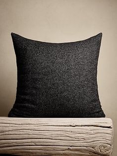 a black pillow sitting on top of a bed