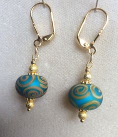 The beads are handmade and hand painted.  The bead color is a beautiful blue-green with a yellow gold painted design.  The findings are high quality yellow gold plated.   I can make just this one pair, one of a kind! Beautiful gift for teacher or mom. Turquoise Earrings With Large Beads For Gifts, Gold Round Beaded Earrings, Turquoise Earrings With Gold Beads For Gift, Unique Hand Painted Blue Earrings, Artisan Blue Beaded Earrings, Gold Hand Painted Dangle Jewelry, Gold Earrings With Large Beads For Gift, Gold Earrings With Large Beads As Gift, Turquoise Large Beads Drop Earrings