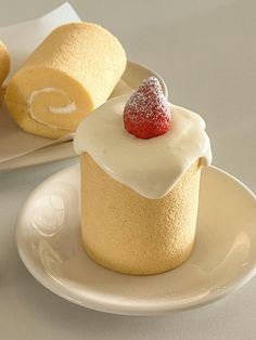 two desserts on plates with white frosting and strawberries in the top one