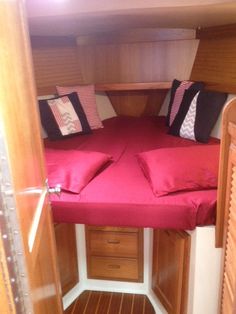 the inside of a small boat with two beds and pillows on it's sides