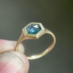 Bezel set signet style ring tapering to 2 mm at back. Choose a unique sapphire in colors ranging from blue to blue green, choose a color of 14k gold, and a ring size. Made to order within about 2-3 weeks. I cut these stones myself in my studio in upstate NY on my Raytech Shaw faceting machine. So the stones are cut in the . US as well as ethically mined here. I draw each ring on my ipad in 3d and send it to my caster who prints and casts it. Then I set the stones and finish the rings using tradi Faceted Sapphire Rings, Faceted Sapphire Round Ring, Faceted Yellow Gold Sapphire Promise Ring, Fine Jewelry Sapphire Ring With Smooth Bezel For Anniversary, Blue Emerald Cut Rings With Bezel Setting, Blue Emerald Cut Ring With Bezel Setting, Sapphire Rings With Bezel Setting And Emerald Cut, Faceted Sapphire Promise Ring, Octagon 14k Gold Sapphire Promise Ring