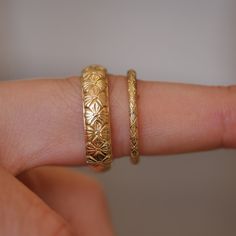 a woman's hand with two gold rings on it