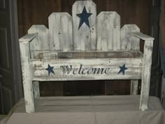 a white wooden chair with blue stars and the word welcome painted on it's back