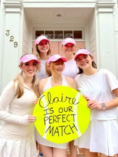 a group of young women standing next to each other in front of a door holding a sign