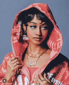 a woman wearing a pink hoodie and jewelry