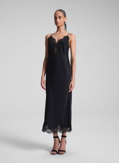 The Lennon Dress is crafted from lustrous black satin with captivating fluidity. This midi-length slip silhouette offers a more directional take on a classic, featuring delicate lace trimming along the neckline, hem, and low back, creating an alluring interplay between masculinity and femininity. Complete with slim, adjustable straps, it strikes a perfect balance between elegance and modern edge. Shop Dresses. Styling Tip: Pair it with minimalist heels and sculptural earrings, finishing with a s Minimalist Heels, Sculptural Earrings, Masculinity And Femininity, Black Lace Midi Dress, Midi Dress Black, Lace Midi, Lace Midi Dress, Black Dresses, Shop Dresses