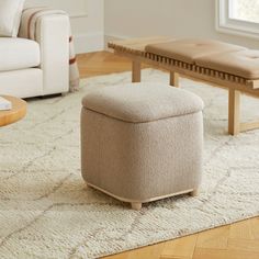 a living room scene with focus on the footstool and coffee table in the background