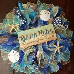 a wreath with beach rules written on it and starfishs hanging from the front