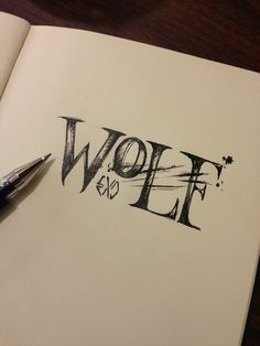 the word wolf is written in black ink on top of an open notebook with a pen