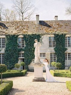 a bride and groom standing in front of a large building with ivy on the walls