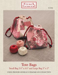 two small bags are sitting on the floor next to some yarn and thread, one is red