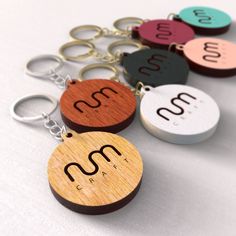 wooden keychains with the letters m and n on them, all in different colors