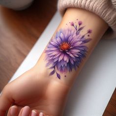 a woman's arm with a purple flower tattoo on it