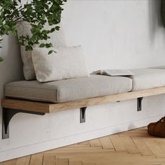 a pair of shoes sitting on top of a wooden bench next to a plant in a room