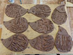 six chocolate fish shaped cookies sitting on top of a wooden table