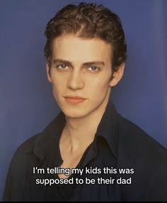 a young man with curly hair and blue eyes is looking at the camera while wearing a black shirt that says, i'm telling my kids this was supposed to be their dad