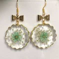 Clear Resin Earrings With Lace Flower & Light Green Flower Over It. It Has A Beautiful Gold Bow Connector. Summer Dangle Jewelry With Flower Decoration, Round Flower Earrings As A Summer Gift, Elegant Floral Print Flower Earrings For Spring, Gold Round Flower Earrings For Spring, Summer Flower Decorated Earrings As Gift, Summer Flower Decoration Earrings As Gift, Elegant Summer Flower Earrings, Summer Flower Decorated Earrings For Gift, Elegant Floral Print Earrings For Spring